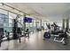 A modern, shared fitness center with floor-to-ceiling windows and various exercise machines and equipment at 845 Spring St # 125, Atlanta, GA 30308