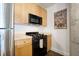 Modern kitchen with wood cabinets, stainless steel appliances, concrete pillar and black gas range at 845 Spring St # 125, Atlanta, GA 30308