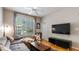 Well-lit living room features a modern sofa, large windows, and sleek entertainment center at 10 Perimeter Summit Ne Blvd # 1204, Brookhaven, GA 30319