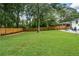 Expansive backyard showcasing a well-maintained lawn, modern fence, and gravel patio area for entertaining at 1048 Pinehurst Se Dr, Smyrna, GA 30080