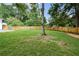 Spacious, fenced-in backyard featuring lush green grass and mature trees offering great privacy at 1048 Pinehurst Se Dr, Smyrna, GA 30080