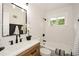 Bright bathroom with a wood vanity, updated fixtures, and a shower-tub combination with white tile at 1048 Pinehurst Se Dr, Smyrna, GA 30080