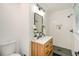 Modern bathroom featuring a wooden vanity, a quartz countertop, and a walk-in shower with black fixtures at 1048 Pinehurst Se Dr, Smyrna, GA 30080