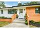 Charming single-story home featuring a modern exterior with wood and painted brick accents, plus a welcoming front porch at 1048 Pinehurst Se Dr, Smyrna, GA 30080