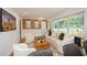 Bright living room with large windows, stylish furniture, wood accent wall, and a decorative fireplace at 1048 Pinehurst Se Dr, Smyrna, GA 30080
