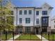 Beautiful townhome exterior with brick accents, a well-manicured lawn, and a charming black metal fence at 1132 Larkin Dr # 34, Buford, GA 30518