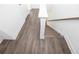 Elegant staircase featuring wood-look floors, white trim, and a wooden handrail, enhancing the home's aesthetic appeal at 1132 Larkin Dr # 34, Buford, GA 30518