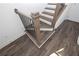 Close-up of stairs featuring hardwood treads, white risers, black balusters, and beautiful hardwood flooring at 1132 Larkin Dr # 34, Buford, GA 30518