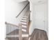 Elegant staircase with wood and white finish plus hardwood flooring, creating a bright and inviting space at 1132 Larkin Dr # 34, Buford, GA 30518