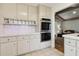 Bright kitchen with white cabinets, double oven, and tile countertops, open to the living area at 3100 Meadow Dr, Marietta, GA 30062