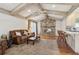 Comfortable living room with a stone fireplace, exposed beam ceiling, and a view into the kitchen at 3100 Meadow Dr, Marietta, GA 30062