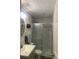Modern bathroom with gray vanity, round mirror, and shower stall with sliding glass door and decorative accent tile at 6308 Boyett Drive Dr, Norcross, GA 30093
