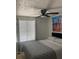 Bright bedroom with ceiling fan, window with blinds, cityscape artwork and a gray and white patterned bedspread at 6308 Boyett Drive Dr, Norcross, GA 30093
