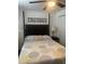 Bedroom featuring a ceiling fan and bed with decorative pillows and a sign that says, 