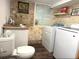 Laundry room with stone-look walls, a window, a sink, a toilet, and a newer model washer and dryer at 6308 Boyett Drive Dr, Norcross, GA 30093