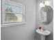 Bathroom featuring a sink, round mirror, lighting, and window to let in natural light at 1780 Brookside Lay Cir, Norcross, GA 30093