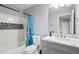Updated bathroom with a modern vanity, a tiled shower-tub combination, and stylish blue patterned shower curtain at 1780 Brookside Lay Cir, Norcross, GA 30093