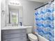 Neutral bathroom features modern fixtures, gray vanity, and a tub with a contemporary fish-themed shower curtain at 1780 Brookside Lay Cir, Norcross, GA 30093