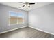 Well-lit bedroom features neutral paint, wood-look floors, ceiling fan, and a large window offering lots of sunlight at 1780 Brookside Lay Cir, Norcross, GA 30093