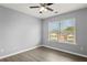 Clean and bright bedroom with a ceiling fan, modern wood flooring, and a view of neighboring houses at 1780 Brookside Lay Cir, Norcross, GA 30093