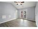 Vaulted-ceiling bedroom features French doors, neutral paint, modern ceiling fan, and attractive wood-look floors at 1780 Brookside Lay Cir, Norcross, GA 30093