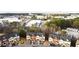 A partial aerial view of colorful townhouse exteriors with lush green trees, nearby parking, and light landscaping at 1780 Brookside Lay Cir, Norcross, GA 30093