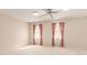 Spacious bedroom with neutral carpet, ceiling fan and windows with pink curtains at 3403 Ashwood Ln, Atlanta, GA 30341