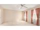Spacious bedroom with neutral carpet, ceiling fan and windows with pink curtains at 3403 Ashwood Ln, Atlanta, GA 30341