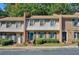 Charming townhome featuring manicured landscaping, a brick facade, and a welcoming teal door at 3403 Ashwood Ln, Atlanta, GA 30341
