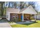 Charming brick home with a bright blue door and cozy front porch seating area at 3706 Clovis Nw Ct, Atlanta, GA 30331