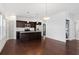 Open concept kitchen with dark cabinets, granite island and stainless steel appliances at 3706 Clovis Nw Ct, Atlanta, GA 30331