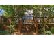 View of back deck with outdoor seating framed by decorative trees in the backyard at 1725 Silverchase Sw Dr, Marietta, GA 30008