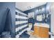 Bathroom with blue walls, wood-look floors, a walk-in shower, and a vanity with a round mirror at 1725 Silverchase Sw Dr, Marietta, GA 30008