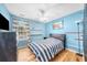 Cozy bedroom featuring light blue walls, wood floors, striped bedding, and a ceiling fan at 1725 Silverchase Sw Dr, Marietta, GA 30008