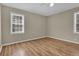 A bedroom with a ceiling fan, two windows, and wood look flooring at 272 Colchester Dr, Stone Mountain, GA 30088