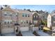 View of townhomes with brick facade, garages, and professionally landscaped front yards at 3567 Hidden Valley Cir, Lawrenceville, GA 30044