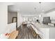 Open concept kitchen and living area features an island with seating, white cabinets, and wood floors at 3567 Hidden Valley Cir, Lawrenceville, GA 30044