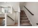 Carpeted staircase with dark handrails leads to the next level, complemented by natural light at 3567 Hidden Valley Cir, Lawrenceville, GA 30044