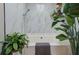 This bathroom features a large soaking tub with tiled walls, a hand shower, and decorative plants for a spa-like ambiance at 403 Oak Harbor Ct, Marietta, GA 30066
