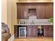 Home bar with custom cabinets, granite countertops, wine rack, and wine cooler at 4437 Blue Ridge Dr, Douglasville, GA 30135