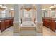 Luxury bathroom with soaking tub surrounded by decorative columns and dual vanities at 4437 Blue Ridge Dr, Douglasville, GA 30135