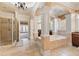 Luxury primary bathroom with arched design, soaking tub, walk-in shower, and natural light at 4437 Blue Ridge Dr, Douglasville, GA 30135