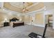 Large primary bedroom with tray ceiling, ceiling fan, and doorway to the bathroom at 4437 Blue Ridge Dr, Douglasville, GA 30135