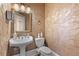 Stylish powder room with decorative walls, pedestal sink, toilet, and ornate mirror at 4437 Blue Ridge Dr, Douglasville, GA 30135