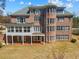 Expansive brick home featuring a sunroom, balcony, and outdoor patio with views of the spacious backyard at 4437 Blue Ridge Dr, Douglasville, GA 30135