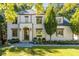 Stunning two-story home with a white brick facade, arched entry, and professionally landscaped front yard at 515 Danube Ne Rd, Atlanta, GA 30342