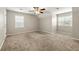 Bright bedroom with neutral carpet, two windows, and a ceiling fan at 2802 Oak Meadow Ln, Snellville, GA 30078