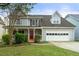 Charming two-story home with a well-manicured lawn and a bright red front door at 2802 Oak Meadow Ln, Snellville, GA 30078
