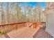 Wood back deck with red railing and wooded view of surrounding nature at 4565 Canebrake Ct, Powder Springs, GA 30127