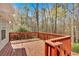 Spacious wood back deck with red railing and wooded view of surrounding nature at 4565 Canebrake Ct, Powder Springs, GA 30127